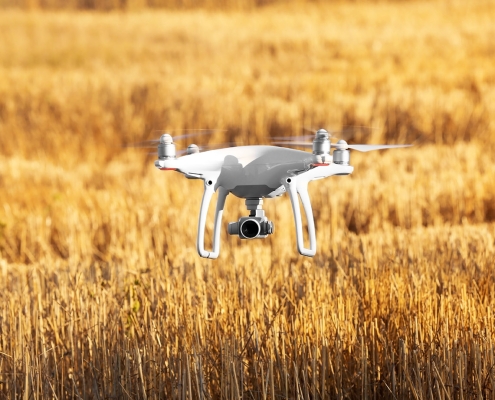 Modern quadcopter flying over field Drone technology